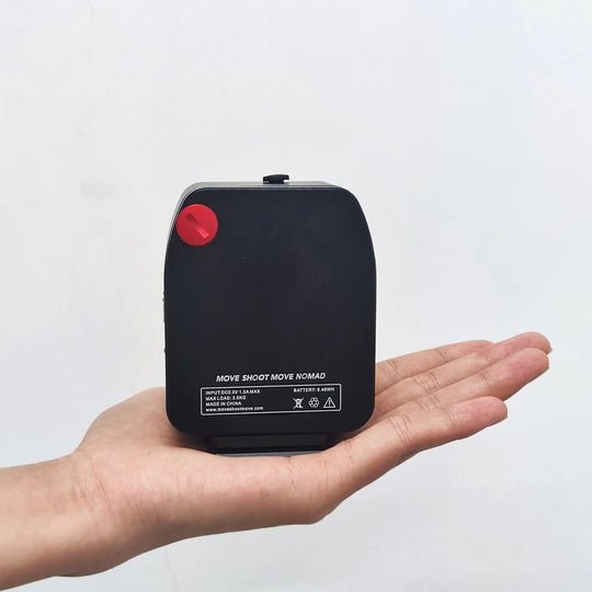 the NOMAD tracker held by a hand